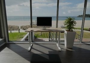 imac on bamboo standing desk with beach in background